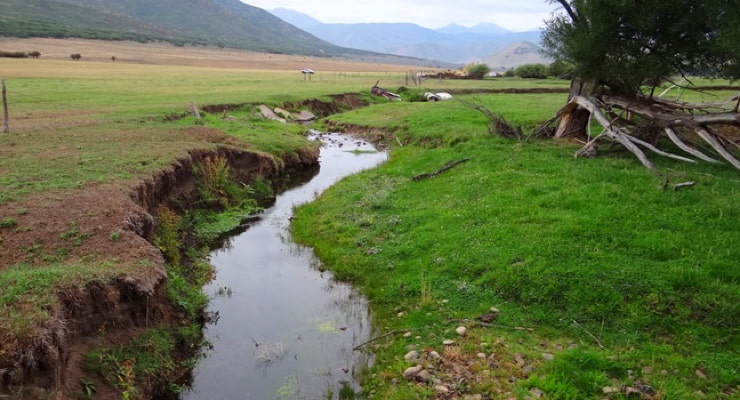 "Evidence of channel erosion is shown alongside the banks of a stream"