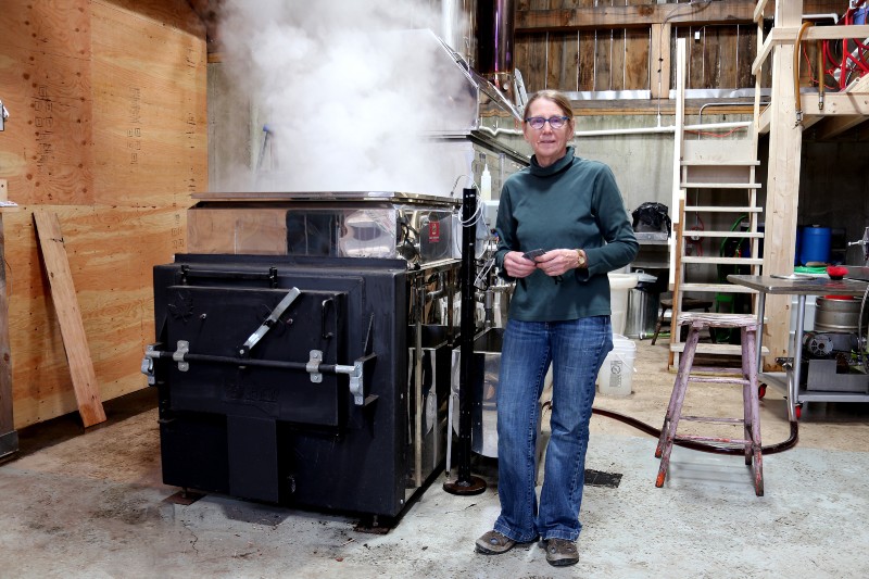 A woman standing next to piece of machinery