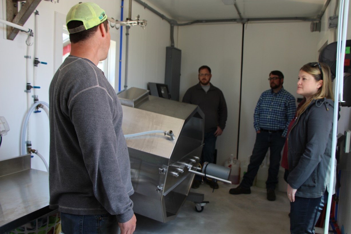 Five People standing in milk bottling room