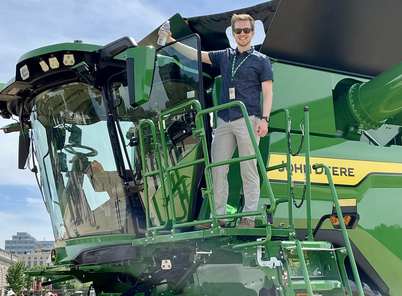 Person standing on a green tractor