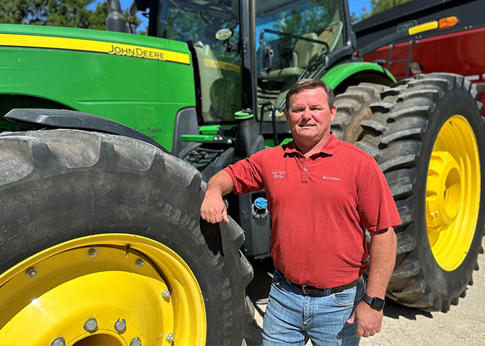 Person leaning on green and yellow tractor