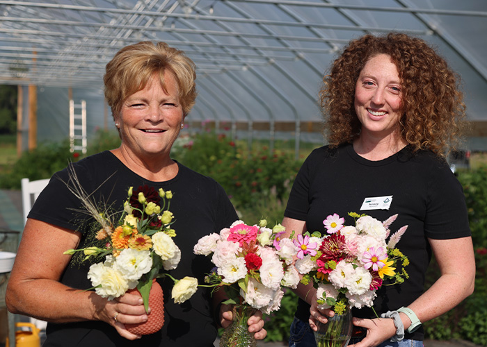 Two people holding flower bouquets