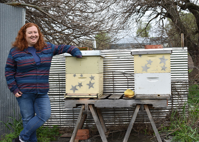 Person leaning on a beehive