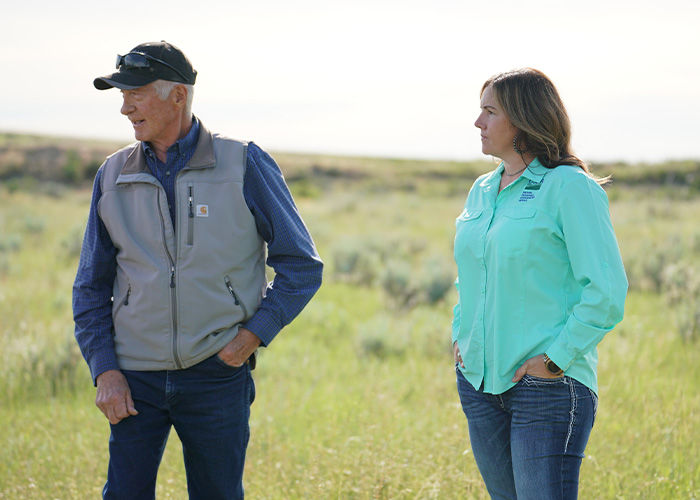Two people standing on prairie land