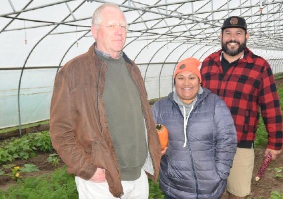 Bill Borgeld, NRCS, with Joe VanAlstine and Rosebud Schneider in a high tunnel with crops.