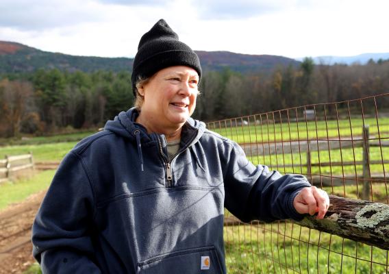 Jan Johnson leans on a fence post