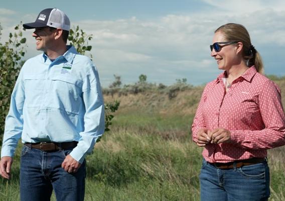 Two people standing on prairie land