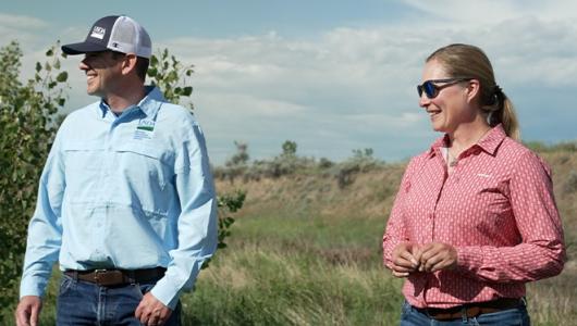 Two people standing on prairie land